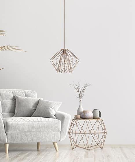 Déco Salon Scandinave : Fauteuil, Luminaire Cuivre, Minimaliste Salon moderne minimaliste avec fauteuil texturé gris clair, suspension géométrique en cuivre et table d'appoint filaire, décorée de vases.